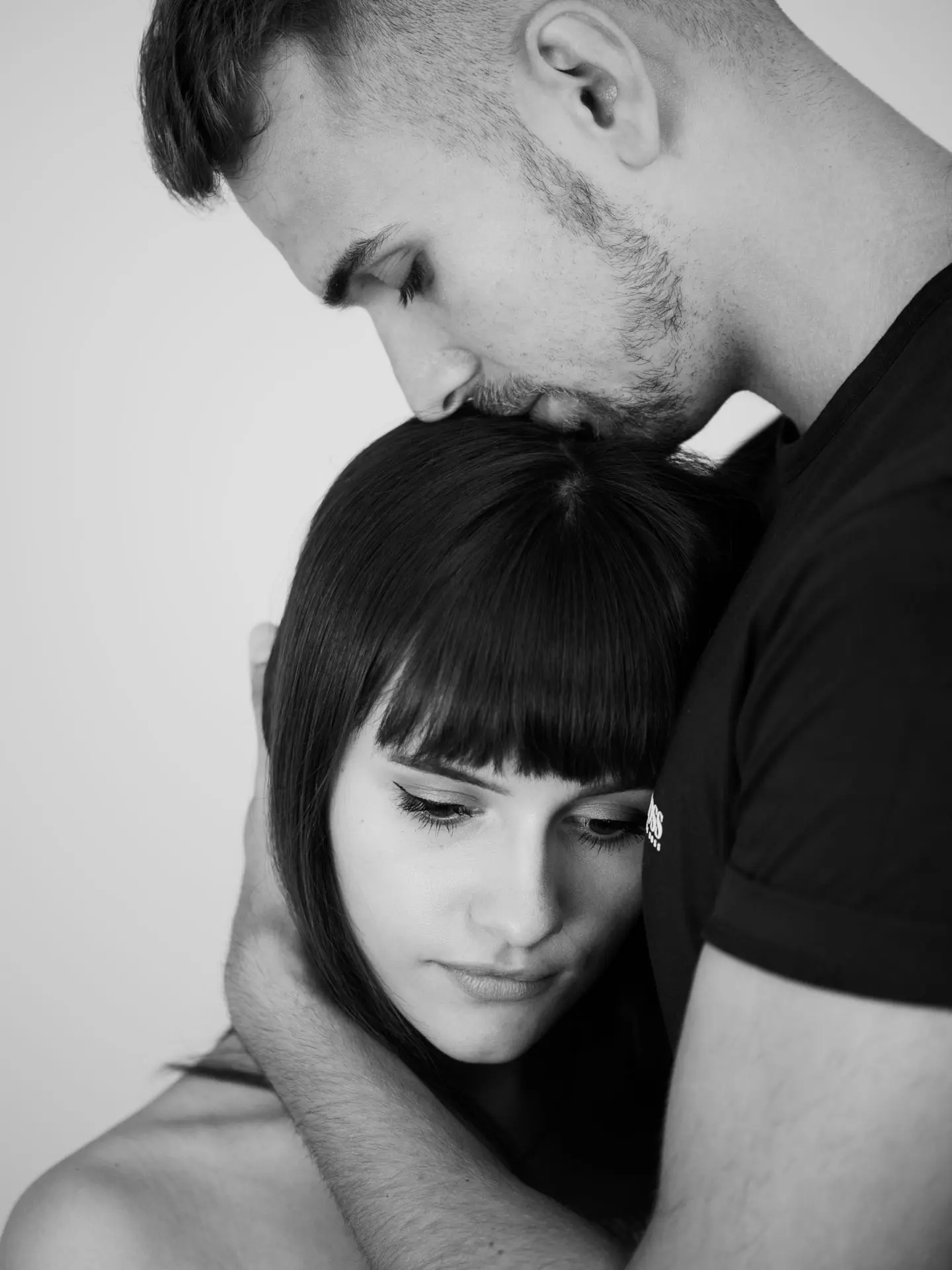 Mann küsst Frau auf den Kopf – zartes Paarfoto schwarz-weiß Leipzig Studio